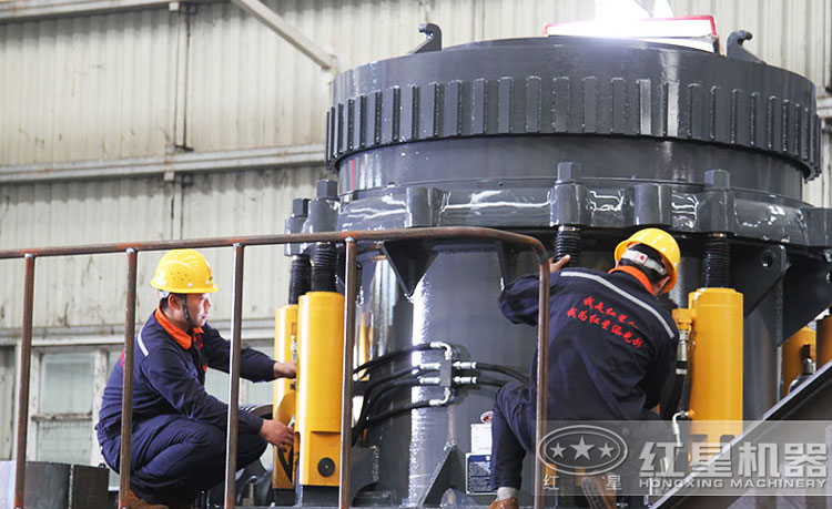 工作人員檢測(cè)圓錐破碎機(jī)，保障生產(chǎn)的設(shè)備都有高質(zhì)量